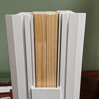 Low Quality Vinyl Window: Cheap bulky wood reinforcement bar