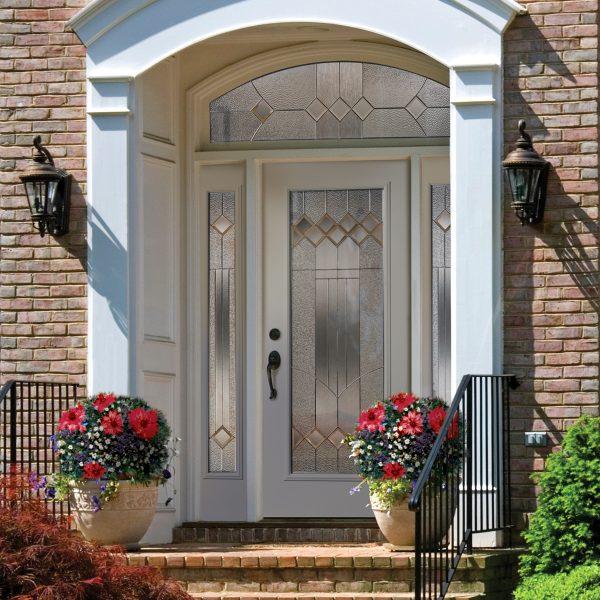 White steel door with sidelights and transom, inserts of decorative glass with grids.